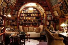 a living room filled with lots of books and furniture