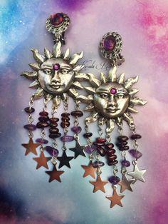 "This pair of Handmade Celestial Earrings is made with antiqued bronze or silver sunshine pendants. Garnet & Amethyst gemstone beads hang from the mystical pair! Celestial star charms dangle from each strand. For an added touch of sparkle a Swarovski rhinestone is on each Sun's third eye. Pierced with french wires (as shown), leverbacks, clip-ons or posts, just select from the pull-down menu. -4 1/2\" Long x 1 3/4\" Wide -0.4. ea. Metal Finishes Available: -Bronze (temporarily sold out) -Sil Sun Chandelier, Wiccan Earrings, Manic Pixie, Celestial Stars, Celestial Earrings, Fantasy Style, Solar Plexus Chakra