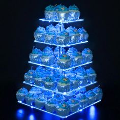 a blue lighted cake stand with cupcakes on it