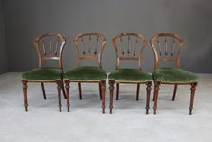 four antique chairs with green velvet upholstered seats