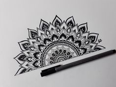 a pen is sitting on top of a piece of paper with a drawing of a flower