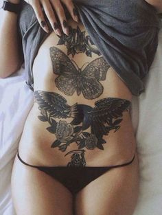 a woman's back with tattoos on her stomach and the bottom part of her panties