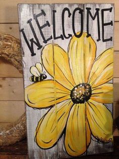 a wooden sign with a yellow flower painted on it