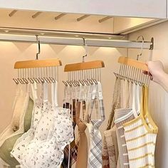 there are many different types of ties hanging on the rack in this closet, and one person is pointing at them