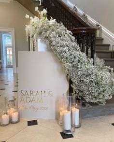 flowers and candles sit on the floor next to a sign that reads, sarai's adam