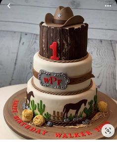 a three tiered birthday cake decorated with cowboy hats and ranch theme on the top