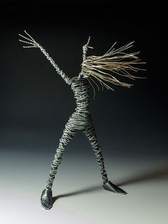 a wire figurine is standing with his arms outstretched