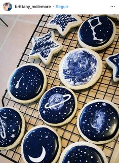 some cookies that are sitting on a cooling rack with stars and planets painted on them