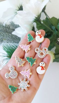 a person is holding some decorated cookies in their hand