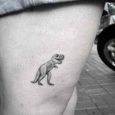 a small dinosaur tattoo on the thigh