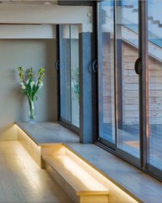 a long bench sitting next to a window in a room