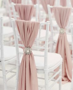 rows of white chairs with pink sashes on them