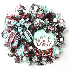 a christmas wreath made out of ribbons and bows with an ornament on it