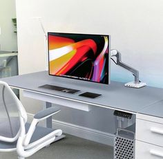 a computer monitor sitting on top of a desk next to a keyboard and mouse pad