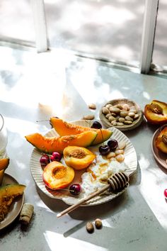 a table topped with plates filled with fruit and nuts