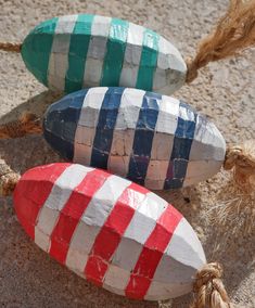 three colorfully painted rocks sitting on the ground