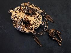 "This handsome, flickering brooch features detailed filigree and cannetille work. The brooch is quite dimensional with raised and dangling ornament. It was probably made in Portugal or Spain. The security clasp works just fine. The brooch is in good shape with some surface wear to the gilding. It is 6.7cm (2 5/8\")long X 3.2cm (1 1/4\")wide. It weighs 10g." Ornate Pendant Brooch For Ceremonial Occasions, Ornate Filigree Brooches For Ceremonial Use, Ornate Brooches With Intricate Design For Formal Occasions, Ornate Brooches With Intricate Design For Ceremonial Use, Gold Brooches With Intricate Design For Ceremonial Occasions, Intricate Pendant Brooches For Weddings, Antique Filigree Brooches For Ceremonial Occasions, Vintage Brooches With Intricate Design For Ceremonial Use, Heirloom Gold Brooches With Intricate Design