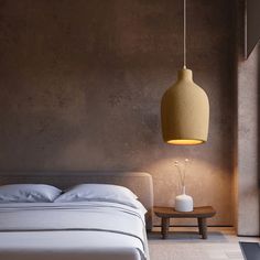 a white bed sitting next to a wooden table with a lamp on top of it