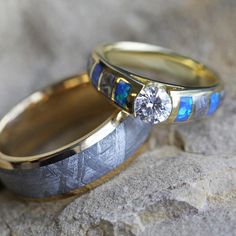 two wedding rings with blue and white opal inlays on top of each other