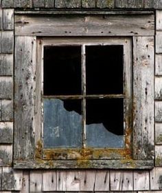 an old wooden building with a broken window