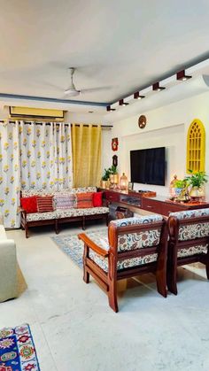 a living room filled with furniture and a flat screen tv on top of a wooden stand