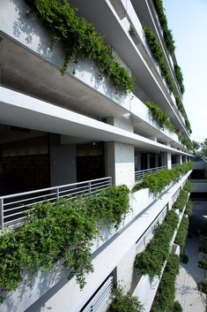 an apartment building with plants growing on the balconies