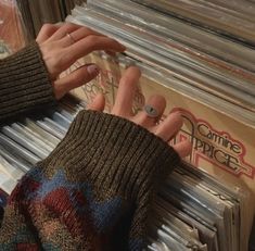 two hands reaching for records on a record rack