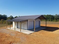 a small white building sitting on top of a dirt field