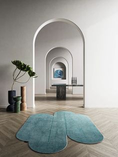 two rugs are on the floor in front of a table and potted plant