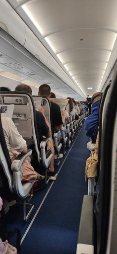 an airplane with people sitting on seats and facing the front row, all looking in different directions