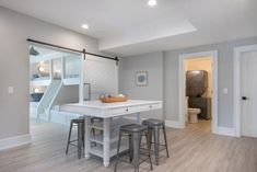 a kitchen with white counter tops and stools