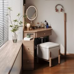 a wooden desk with a mirror, stool and potted plant