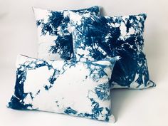 three blue and white pillows sitting next to each other