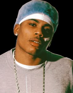 a young man wearing a hat and chain around his neck