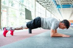 a man is doing push ups on the floor in an indoor gym with red shoes