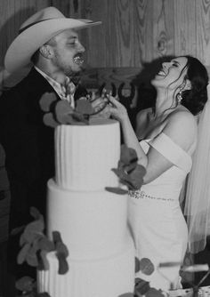 a bride and groom feeding each other a piece of wedding cake at their wedding reception