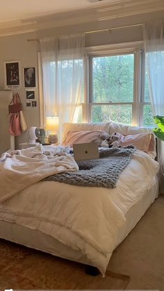 a bed room with a neatly made bed and a laptop on the top of it