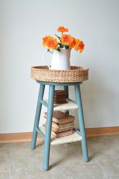 a basket with flowers sitting on top of a stool next to a stack of books