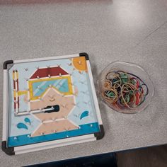 there is a plastic tray with some rubber bands in front of it on the table