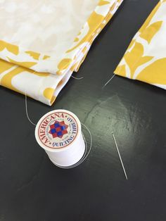 the sewing thread is next to some fabric and a spool of thread on a table