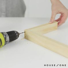 a person using a power drill to attach a piece of wood with a screwdriver