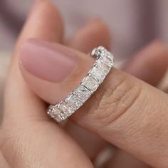 a woman's hand with a wedding ring on her finger and an engagement band in the middle