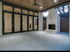 an empty patio with a fireplace and sliding glass doors