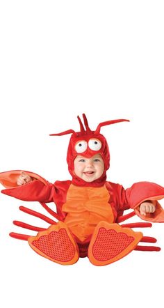 a baby in a lobster costume sitting on the ground with his hands out and eyes wide open