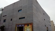 a building made out of blocks with an advertisement on the front and side wall in chinese