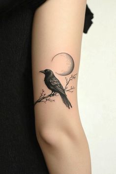 a black bird sitting on a branch with the moon in the sky behind it tattoo