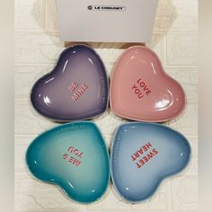 four heart shaped dishes with words on them