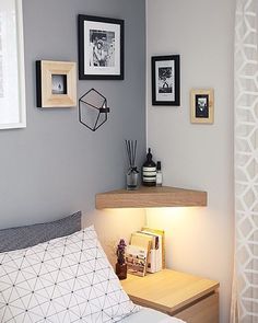 a bedroom with grey walls and pictures on the wall above the bed, along with a small desk