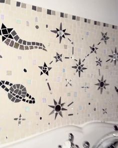 a white sink sitting under a mirror next to a tiled wall