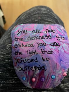 a painted rock with the words you are not the darknesss you end up in